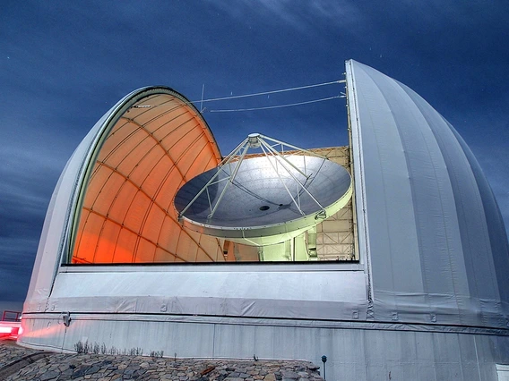 At night, the open dome reveals the dish of the Arizona Radio Observatory's 12-meter Telescope on Kitt Peak 