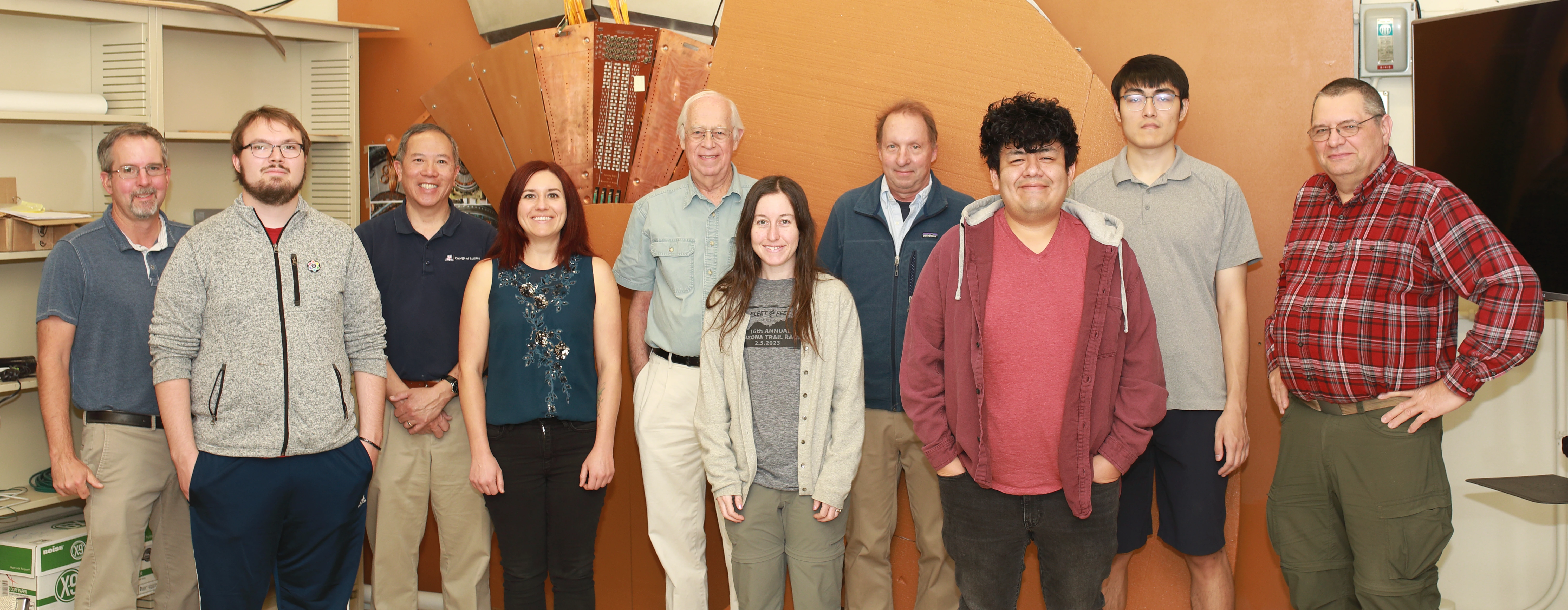 A line of people from left to right pose for a group picture.