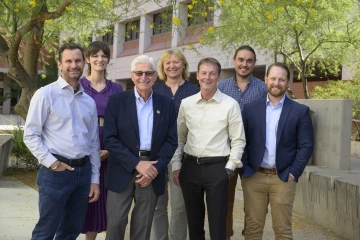 Group of seven people posed outside at the University of Arizona